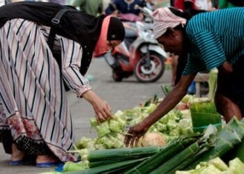 Pedagang melayani pembeli bungkus ketupat jelang Hari Raya Idul Fitri di Pasar Paldam, Jayapura, Papua, Minggu (1/5/2022) / (ANTARA/GUSTI TANATI)