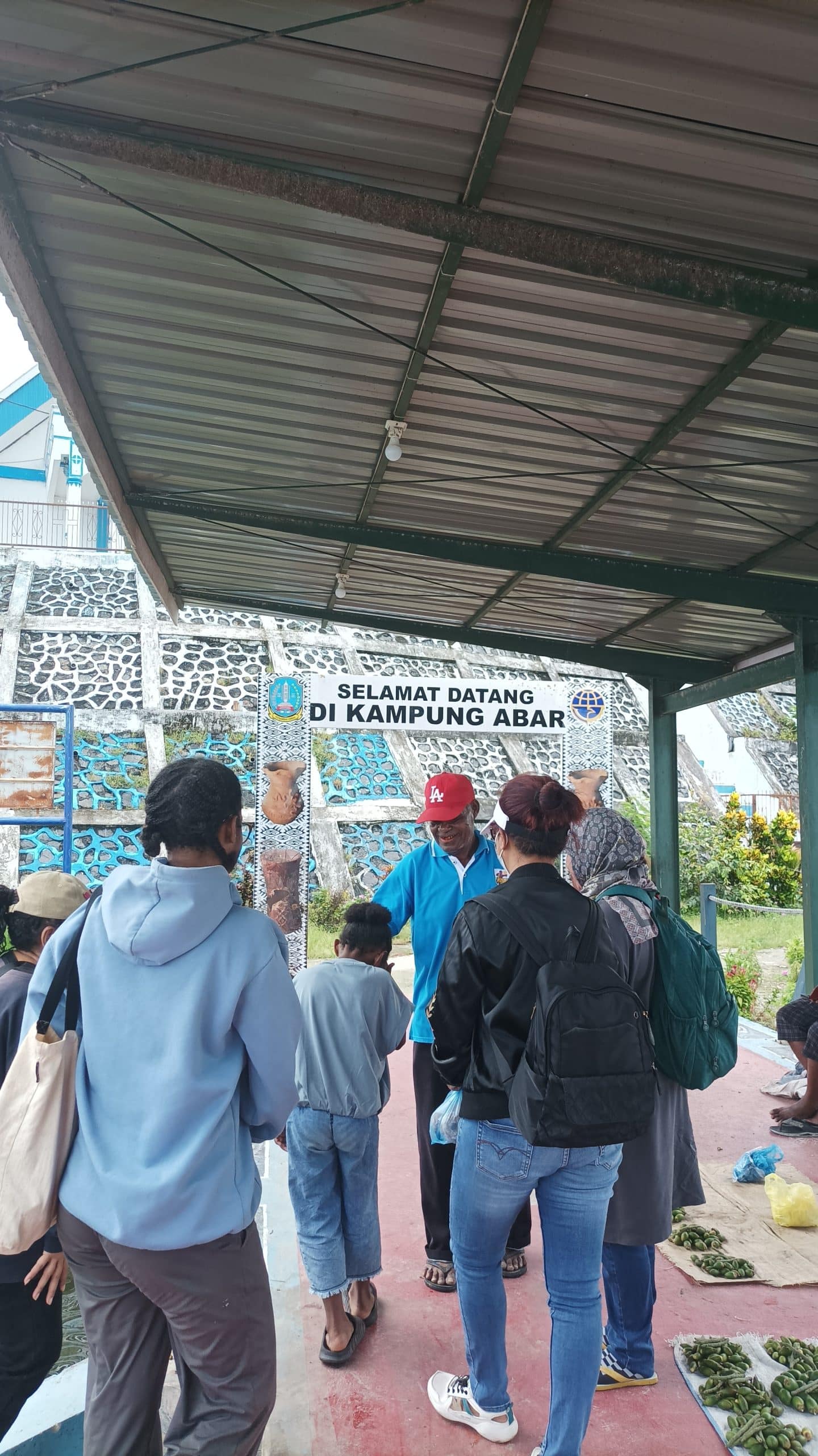 Ketua Kelompok Pengrajin Gerabah Tradisional “Titian Hidup”, Naftali Felle (baju biru topi merah) menyambut peserta kegiatan Menoken Gerabah. Jubi/Fitri Ramadhani
